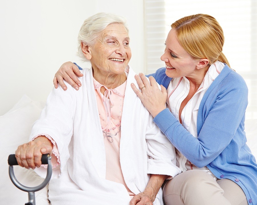 Happy senior citizen woman at home looking at her daughter