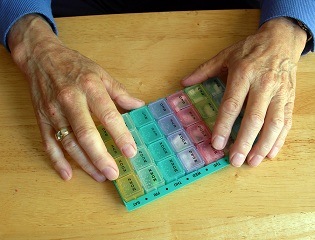image of elderly hands holding pills like statins