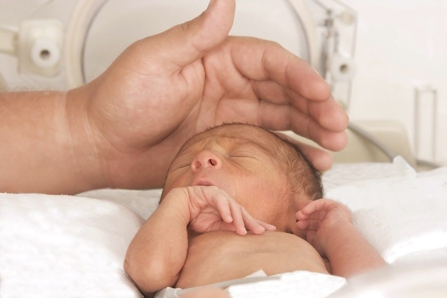 Portrait of newborn baby sleeping inside incubator